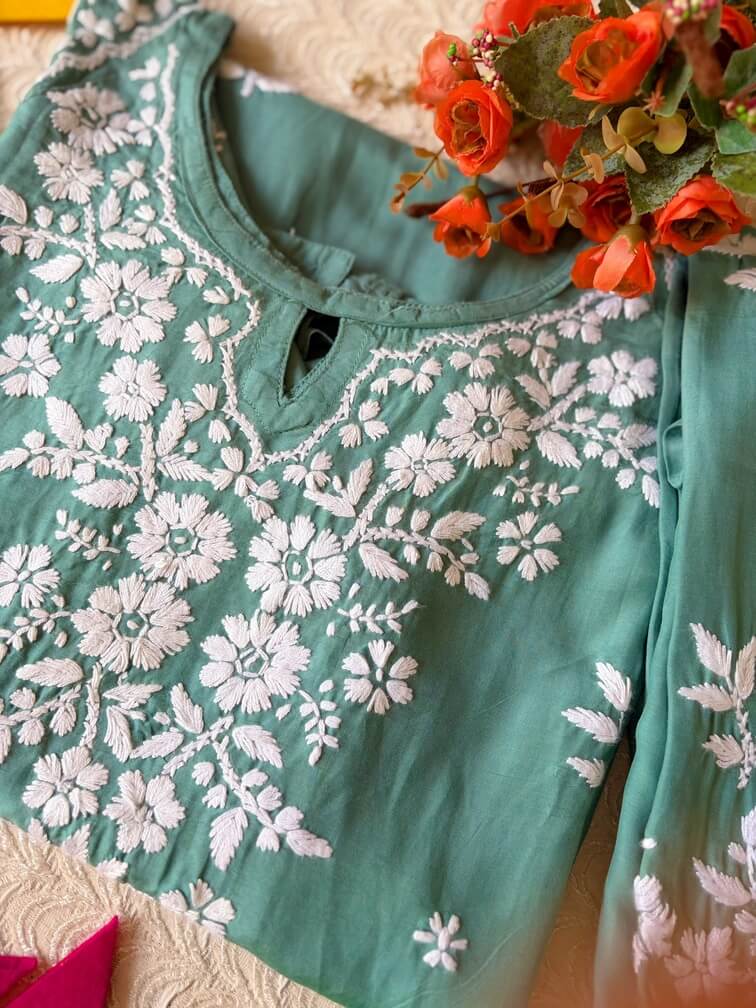 Pastel Sea Green Muslin Chikankari Kurta Set 2 Close-up of the folded pastel sea green muslin chikankari kurta set showcasing intricate chikankari embroidery.