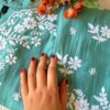 Folded detail of the Pastel Sea Green Muslin Chikankari Kurta Set highlighting delicate chikankari embroidery.